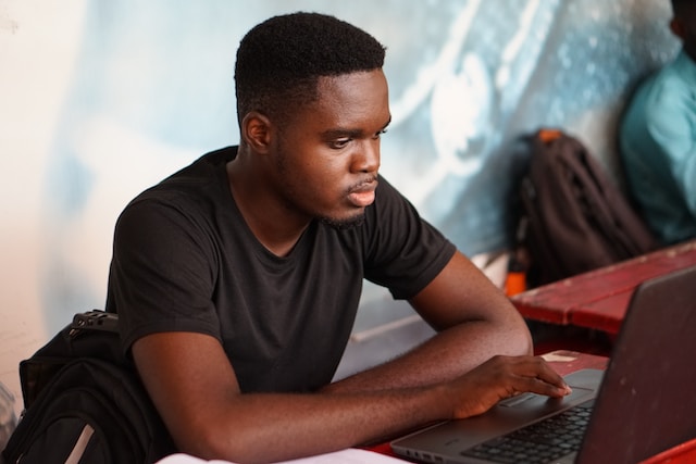 Image of a person studying using a laptop. Photo by Kojo Kwarteng on Unsplash
